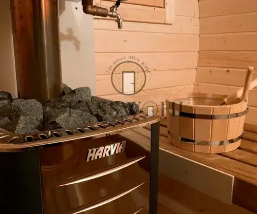 Saunasteine liegen auf dem Ofen der Fasssauna