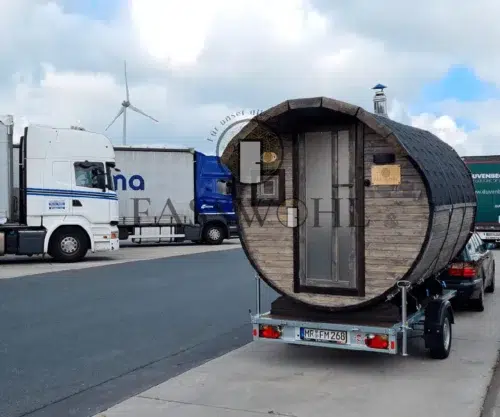 Eine Holz Fasssauna auf dem Rastplatz mit LKWs im Hintergrund