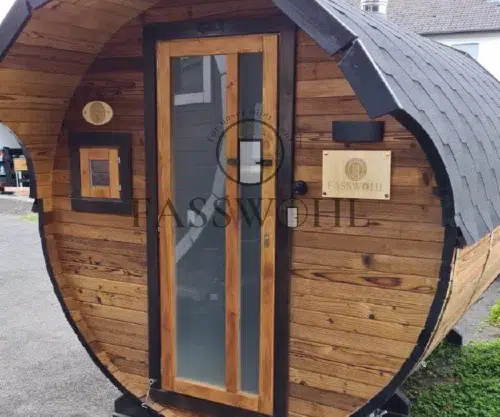 Ein Fasssauna Bild vor dem Haus eines Fasswohl Kunden