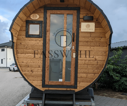 Eine Fasssauna steht auf einem Anhänger auf einem Rasthof