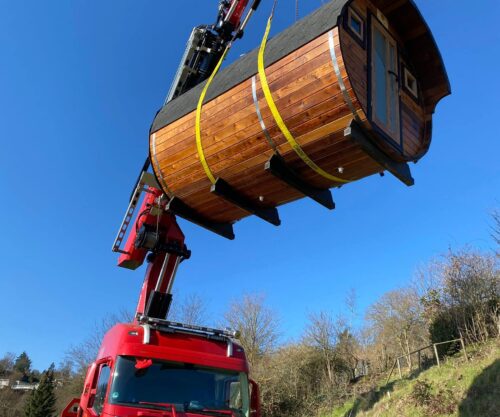 Das Saunafass wird mit einem Kran über einen LKW gehoben
