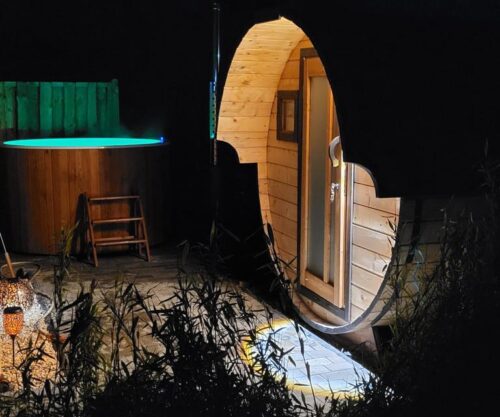 Beleuchtete Fasssauna im Garten