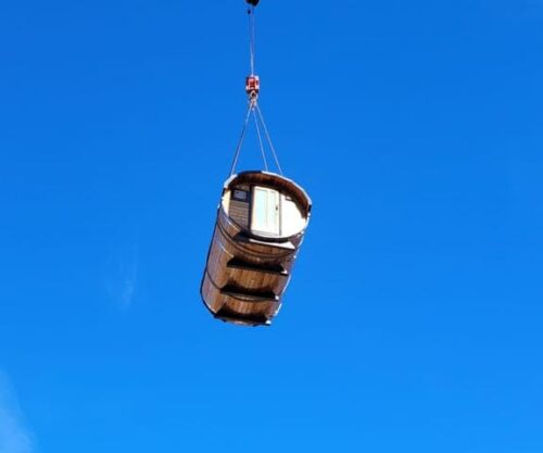 Eine Fasssauna wird mit einem Kran geliefert